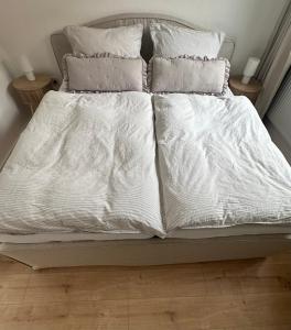 a bed with white sheets and pillows on it at Ferienwohnung am Park in Brilon