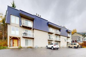 a large building with cars parked in a parking lot at Slope-Walk Condo in Sandpoint