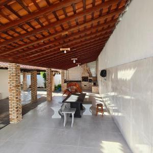 a patio with a table and chairs under a wooden ceiling at Dunas House in Luis Correia