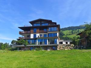 a large building on top of a green hill at Reiterhof in Westendorf