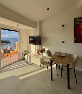 a living room with a dining table and a television at Brand new Big Blue in Jelsa