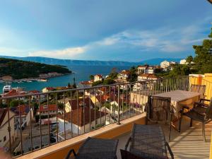 a balcony with chairs and a table and a view of the water at Brand new Big Blue in Jelsa