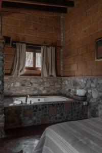 ein Badezimmer mit einer Badewanne in einer Ziegelwand in der Unterkunft Armadillo Mágico in Armadillo + 59 Fotos