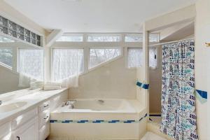 a bathroom with a tub and a sink and windows at La Casa De La Playa in Gloucester +37 photos