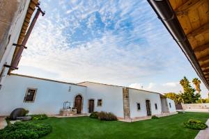 an exterior view of a white building with a yard at Casal Sikelio in Cassibile
