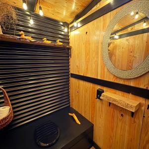 ein Badezimmer mit Spiegel und Holzwand in der Unterkunft Basecamp3105 in Sooke + 16 Fotos