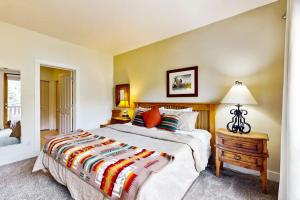 a bedroom with a large bed and a table with a lamp at Wood River Condo in Ketchum