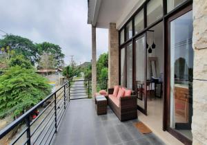 a balcony with a couch and a view of a river at Serenity Nirvana Palace -Private Rooms & Suitable for families Jimbaran in Jimbaran