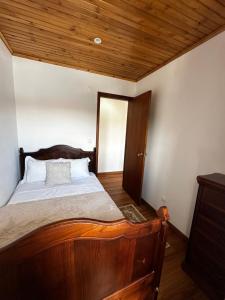 a bedroom with a wooden bed and a wooden ceiling at Ron House in São Caetano