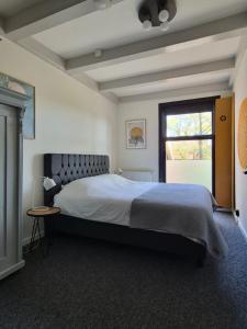 a bedroom with a large bed and a window at De Bloesemstee - Rustic Manor Farmhouse The Netherlands in Ruinerwold