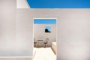 a room with a table and chairs in a white wall at Masseria Guadalupe, The Mascienda in Ostuni