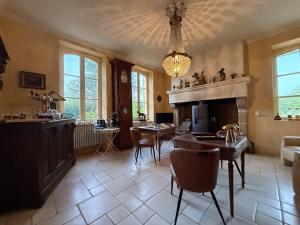 a living room with a fireplace and a table and chairs at En bord de rivière in Casseneuil