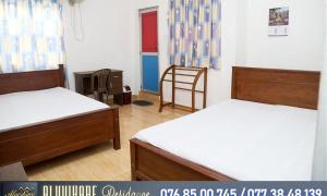 a bedroom with two beds and a chair in it at Nixon Anroos in Kavudupelella