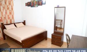 a bedroom with a bed and a mirror and a table at Nixon Anroos in Kavudupelella