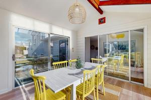 a dining room with a table and yellow chairs at Ledge on Green in Rockport