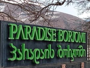 a sign for a parakeet borne restaurant with a mountain in the background at Borjomi Paradise in Borjomi