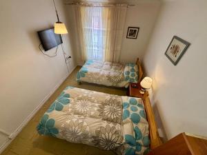 a small bedroom with a bed and a small bed and a tv at Alojamiento La Rosa in Combarbalá