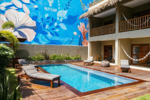 a swimming pool in front of a building with a mural at Vila Tuga in Prea +82 photos