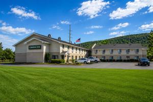 ein Hotel mit einer grünen Wiese davor in der Unterkunft Corning Inn in Painted Post