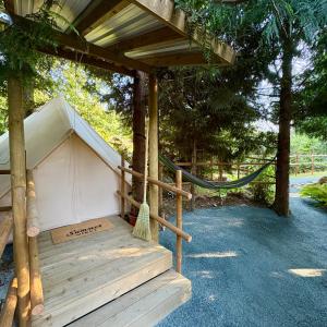 ein Zelt mit einer Hängematte unter einem Baum in der Unterkunft Basecamp3105 in Sooke