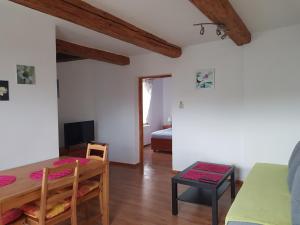 a living room with a table and a room with a bed at Apartaments Am Schloß in Bevern