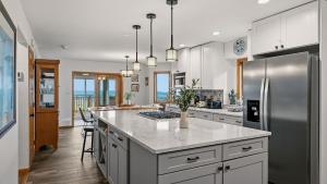 a kitchen with white cabinets and a stainless steel refrigerator at Stone Ridge by AvantStay in Albrightsville