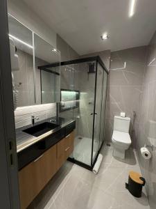 a bathroom with a shower and a toilet and a sink at V-Home Flat Hotel in Macaé