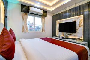 a bedroom with a large bed and a flat screen tv at Hotel Aarnika Villa in New Town
