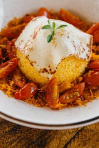 a plate of food with corn and tomatoes on a table at Vila Tuga in Prea