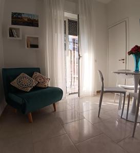 a living room with a green chair and a table at ROUTE 96 Guest House in Modugno