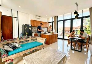 a group of people sitting at a table in a kitchen at Serenity Nirvana Palace -Private Rooms & Suitable for families Jimbaran in Jimbaran
