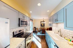 a kitchen with white cabinets and a stove top oven at Bellflower Trout House in Vail
