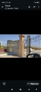 a picture of a sign with a fence and a car at Appartement à Sable d'or tanger in Tangier