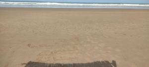 a shadow of a person walking on the beach at Appartement à Sable d'or tanger in Tangier