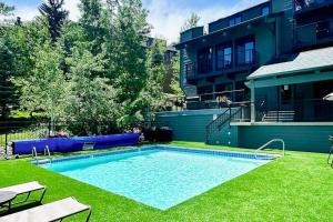 a swimming pool in a yard next to a building at Snowmas Village A4 in Snowmass Village