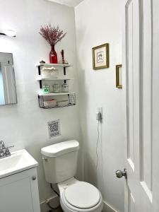 a white bathroom with a toilet and a sink at Sanctuary Retreat Florida HardRock in Hollywood