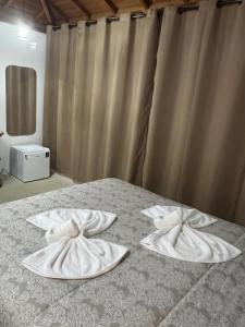 a bed with two white towels on top of it at Pousada São Bento in Cunha +109 photos