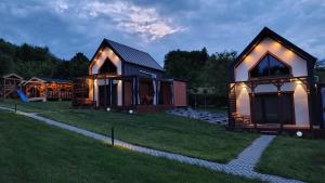 a house with lights on the side of a yard at LoftLove roztocze domek in Jędrzejówka