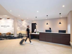 a person walking through a lobby of a mehridine clinic at Mercure Sydney Bankstown in Bankstown