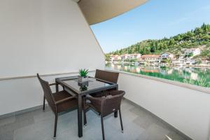 a balcony with a table and chairs and a view of the water at Margaritum Blace - Seaview Apartment with Balcony in Blace