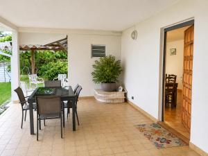 a dining room with a table and chairs at Le JUJUBIER in Le Robert