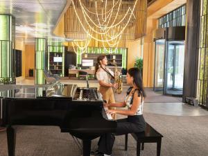 two women playing a saxophone in a room with a piano at ibis Almaty Jetisu in Almaty