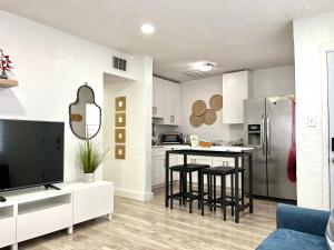 a kitchen with white cabinets and black stools in a room at Sanctuary Retreat Florida HardRock in Hollywood +17 photos