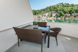 a table and chairs on a balcony with a view of a lake at Margaritum Blace - Seaview Apartment with Balcony in Blace