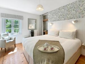 a bedroom with a bed with a tray with two teaisers on it at Glen Cottage Porlock in Porlock