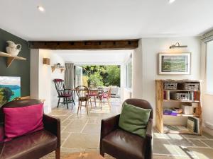 a living room with two chairs and a table at Glen Cottage Porlock in Porlock