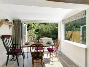 a dining room with a table and chairs and a window at Glen Cottage Porlock in Porlock