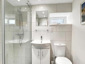 a white bathroom with a toilet and a sink at Glen Cottage Porlock in Porlock +25 photos