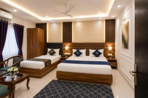 a hotel room with two beds and a table at Hotel ONBellamount Comfort Villa Delhi Airport - Free Airport PickUp & Drop in New Delhi