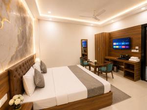 a hotel room with a bed and a desk at Hotel ONBellamount Comfort Villa Delhi Airport - Free Airport PickUp & Drop in New Delhi